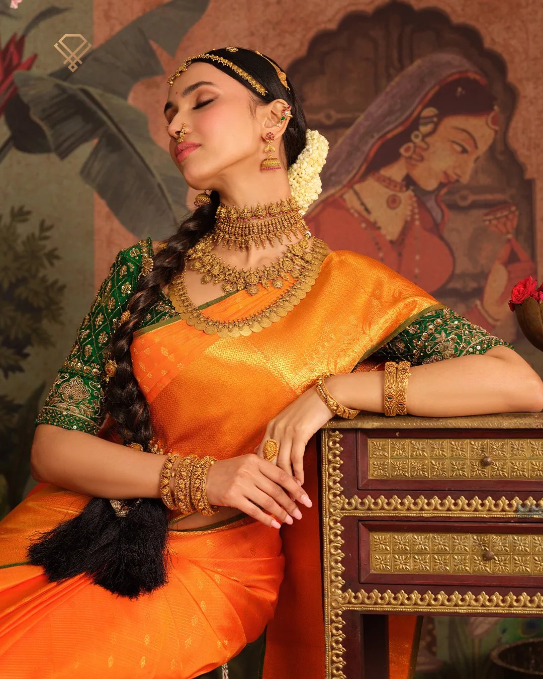 Meralda muse in saffron silk against a peacock mural